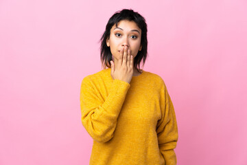 Young Uruguayan woman over isolated pink background covering mouth with hand