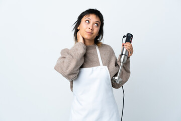 Chef Uruguayan girl using hand blender over isolated white background thinking an idea