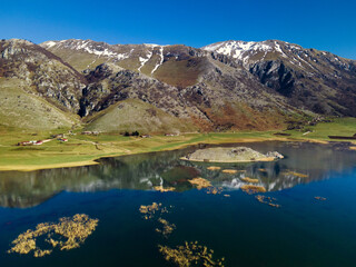 Fototapeta na wymiar View of the mountain lake. Snowy mountains are displayed in a crystal clear lake. Lake Matese, province of Caserta Italy