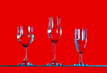 arious drinks filled with water are placed on a bright red background