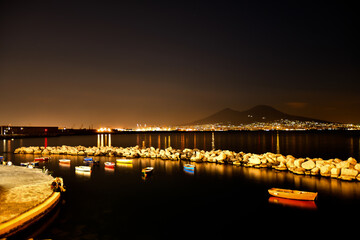 Obraz premium Night view of small boats visible from the waterfront of the Italian city.