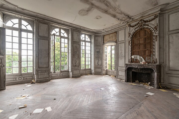 Large room in an abandoned and dilapidated castle with fireplace and broken mirror