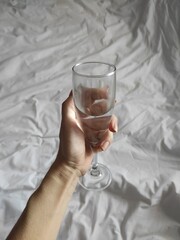 Holding glass with blanket in background 