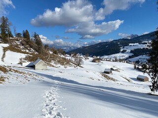 Fototapeta na wymiar Wonderful winter hiking trails and traces on the slopes of the Alpstein mountain range and in the fresh alpine snow cover of the Swiss Alps - Unterwasser, Switzerland (Schweiz)