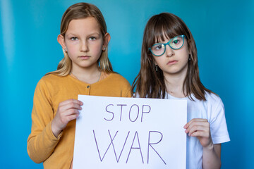 Two unhappy school girl with Board No war, Stop war. No war with Ukraine. Ukrainian geopolitics globe crisis. Hope for the world. Anxiety and anticipation. Children's tears.