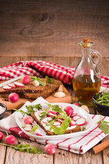 Obraz na płótnie Canvas Rye bread with cottage cheese, radish and arugula.