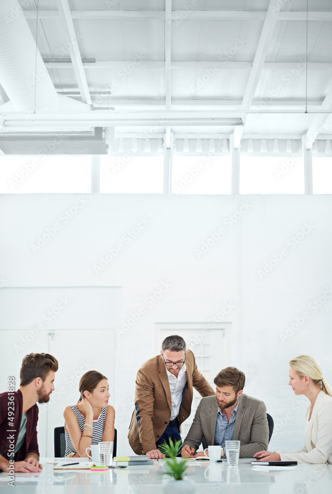 Poster brainstorming for future success. a group of coworkers standing around a table.