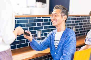 飲食店で電子マネー決済をする男性