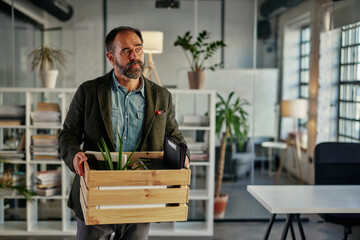 Fototapeta premium Businessman coming back to work and carrying office supplies