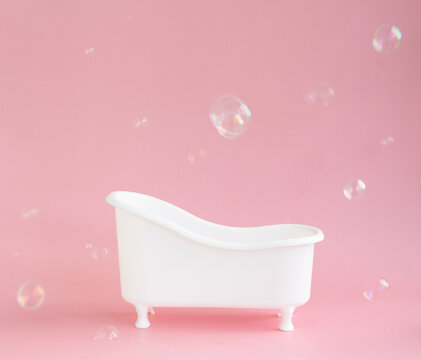 Empty White Bathtub Toy On A Pink Background And Soap Bubbles Foam