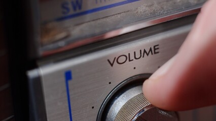 The hand turns the volume control on the music device. Volume to maximum - macro