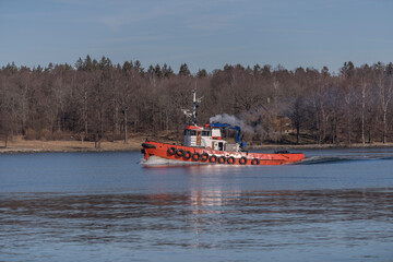 A red tug boat on its way from the archipelago a sunny spring day in Stockholm