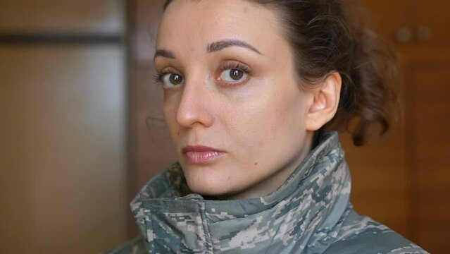 Indoor portrait of young girl wearing military uniform, mandatory conscription in Ukraine, Russian invasion, war concepts