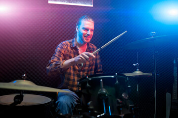 man musician playing on drums in music studio