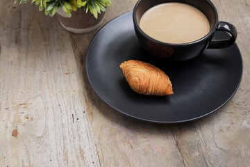 Delicious Curry Puff or Karipap with a cup of coffee on the wooden table 