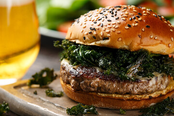 Juicy Beef burger with crispy kale, sweet potato fries and beer
