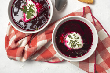 Traditional Ukrainian and Russian national red borscht soup en bol with sour cream and herbs
