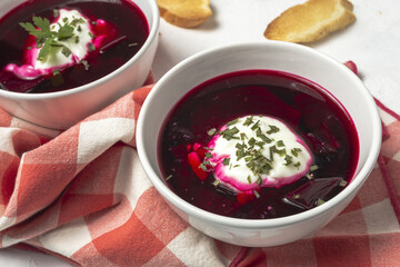 Traditional Ukrainian and Russian national red borscht soup en bol with sour cream and herbs