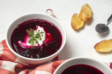 Traditional Ukrainian and Russian national red borscht soup en bol with sour cream and herbs