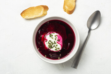 Traditional Ukrainian and Russian national red borscht soup en bol with sour cream and herbs