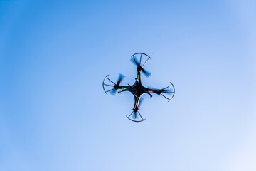Drone camera quad copter flying in the blue sky. Drone photography videography aerial wireless technology