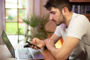 jeune employé ou homme d'affaire en train de travailler sur son ordinateur portable et qui utilise...