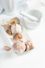Fresh garlic bulbs on a white table.