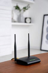 Modern Wi-Fi router on wooden table indoors - obrazy, fototapety, plakaty