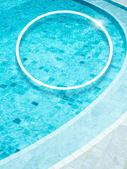 Fototapeta na wymiar A round shape of a white line makes a decorated circle frame on the swimming pool background, vertical style. Empty blank space border frame for summer, vacation time, holiday concept.