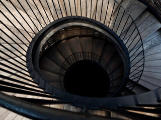 Spiral staircase.  Image of wooden and iron spiral stairway down to the dark.