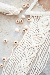 Wall panel in the style of Boho made of cotton threads in natural color using the macrame technique for home decor. close up