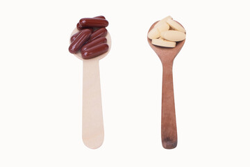 On top view Drug and capsule Variety of vitamin brown and mineral pills in wooden spoon isolated on white background, Dietary supplement health care product. health love concept.