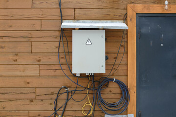 Electrical panel on a wooden wall with wires.