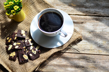 Cup of coffee and tasty cookies on wooden background. Tea time and breakfast concept.