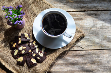 Cup of coffee and tasty cookies on wooden background. Tea time and breakfast concept.