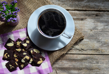 Cup of coffee and tasty cookies on wooden background. Tea time and breakfast concept.