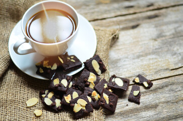 Cup of coffee and tasty cookies on wooden background. Tea time and breakfast concept.