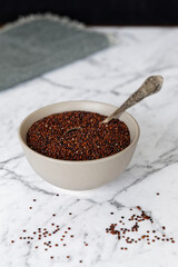 Red quinoa grains in bowl on atable. Healthly gluten free vegan food.