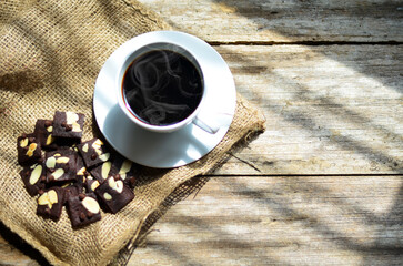 Cup of coffee and tasty cookies on wooden background. Tea time and breakfast concept.
