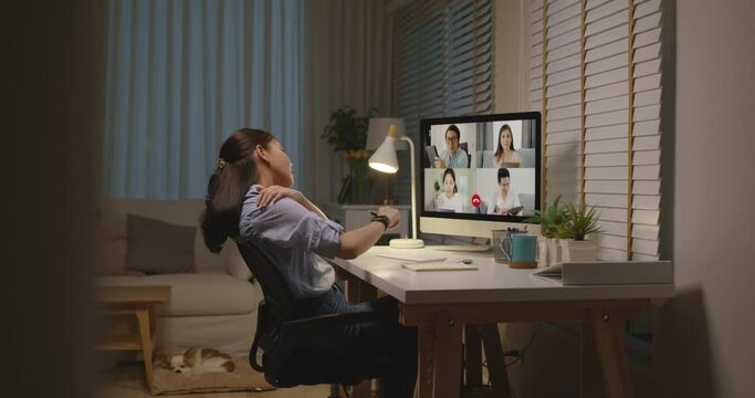 Young asia female busy late night work hard video call online remote group talk stiff neck relief pain ache sit on desk computer in chronic suffer burnout brownout office syndrome workforce at home.