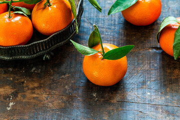 Mandarin oranges with green leaves on wooden table