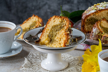 Pistachio and orange cake sprinkled with icing sugar and crushed pistachio nuts