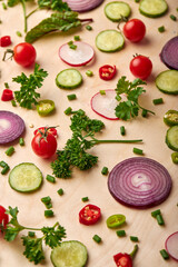 slices of cucumber, onion, greenery, tomato cherry popular spices concept. top view on fresh beautiful vegetables scattered on soft yellow background, top view, flat lay