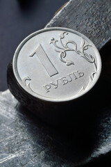 Russian coin with a face value of 1 ruble. and an old working tool. close-up. translation of the...
