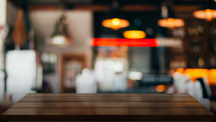 Empty wooden table top with lights bokeh on blur restaurant background.	