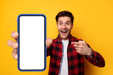 Excited guy pointing at black empty smartphone screen