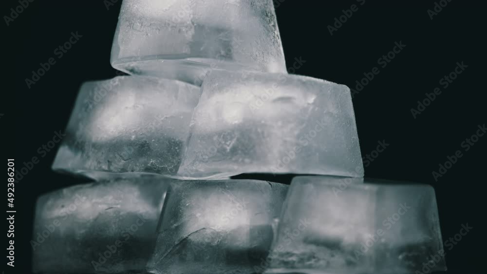 Poster square ice cubes are spinning on a black background. water freezing in square shape. wet ice rotates