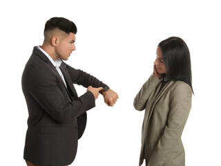 Businessman pointing on wrist watch while scolding employee for being late against white background