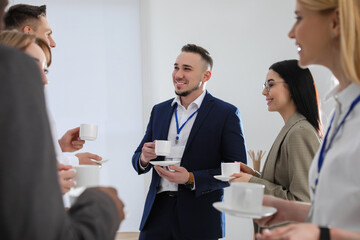 Group of people chatting during coffee break indoors