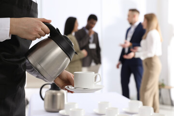 Waitress pouring hot drink during coffee break, closeup